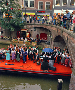840363 Afbeelding van een zangkoor dat zingt op een 'muziekboot' op de Oudegracht bij de Bezembrug te Utrecht, tijdens ...